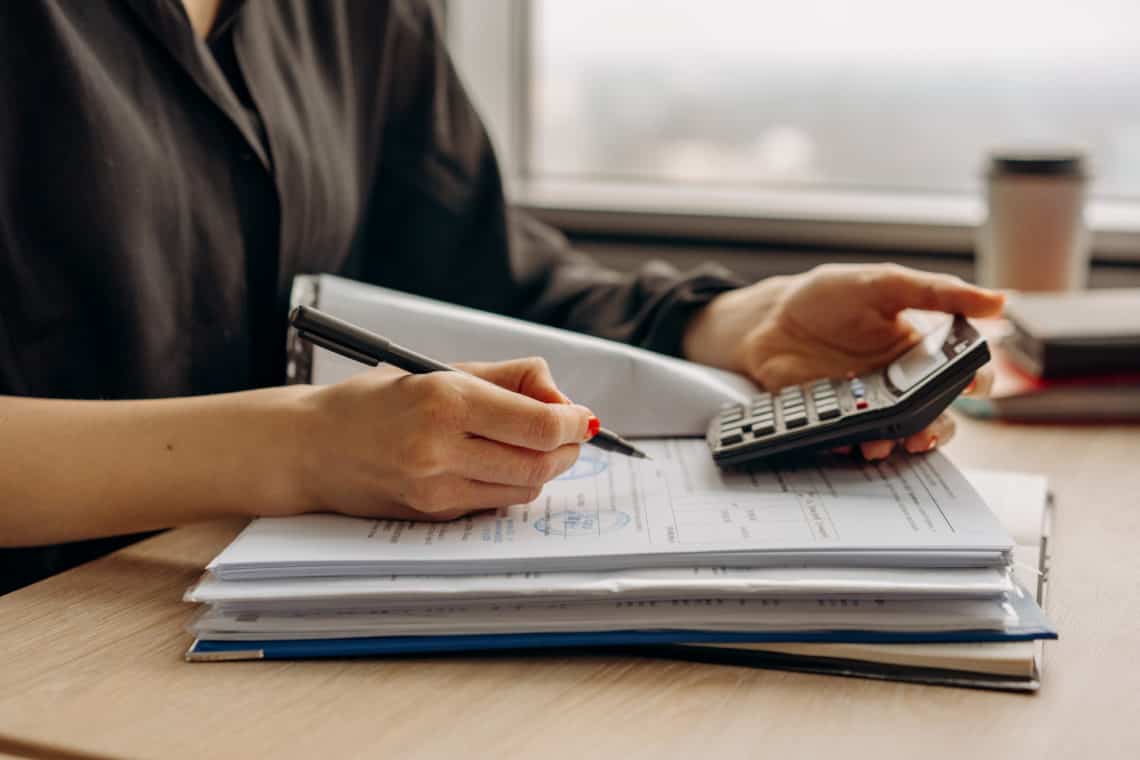 Photo by Mikhail Nilov from Pexels: https://www.pexels.com/photo/person-in-long-sleeve-shirt-holding-a-calculator-8297031/