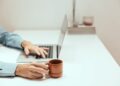 Photo by Cup of  Couple: https://www.pexels.com/photo/a-person-holding-a-cup-while-using-a-laptop-8472565/