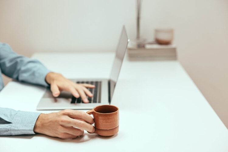 Photo by Cup of  Couple: https://www.pexels.com/photo/a-person-holding-a-cup-while-using-a-laptop-8472565/