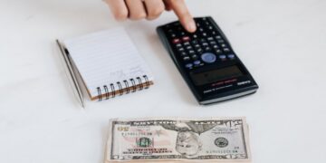 Photo by Photo By: Kaboompics.com: https://www.pexels.com/photo/crop-unrecognizable-accountant-using-calculator-near-pile-of-american-dollars-4386322/