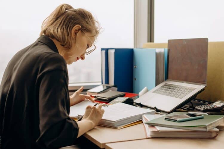 Photo by Mikhail Nilov: https://www.pexels.com/photo/woman-holding-a-pen-reading-notes-in-a-book-binder-8297033/