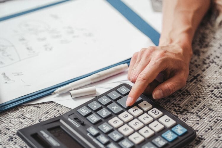 Photo by SHVETS production: https://www.pexels.com/photo/a-person-using-a-calculator-9052475/